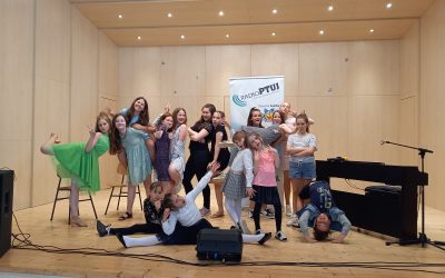 Otroci pojejo slovenske pesmi in se veselijo